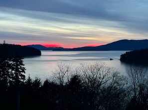 Een rustig meer met bergen in de verte en een heldere lucht.