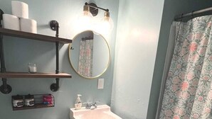 Une salle de bain équipée de toilettes, d’un lavabo et d’un rideau de douche.