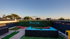 A rooftop terrace with a green wall, a blue sofa, and a sign that reads "Music City." - Sweet Beat by ES ★ 4/4 ★ 13 Beds ★ Rooftop ★ HUGE (Nashville)