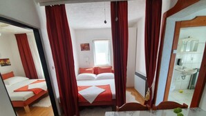 Une chambre d’hôtel avec un lit, une petite table et un miroir.