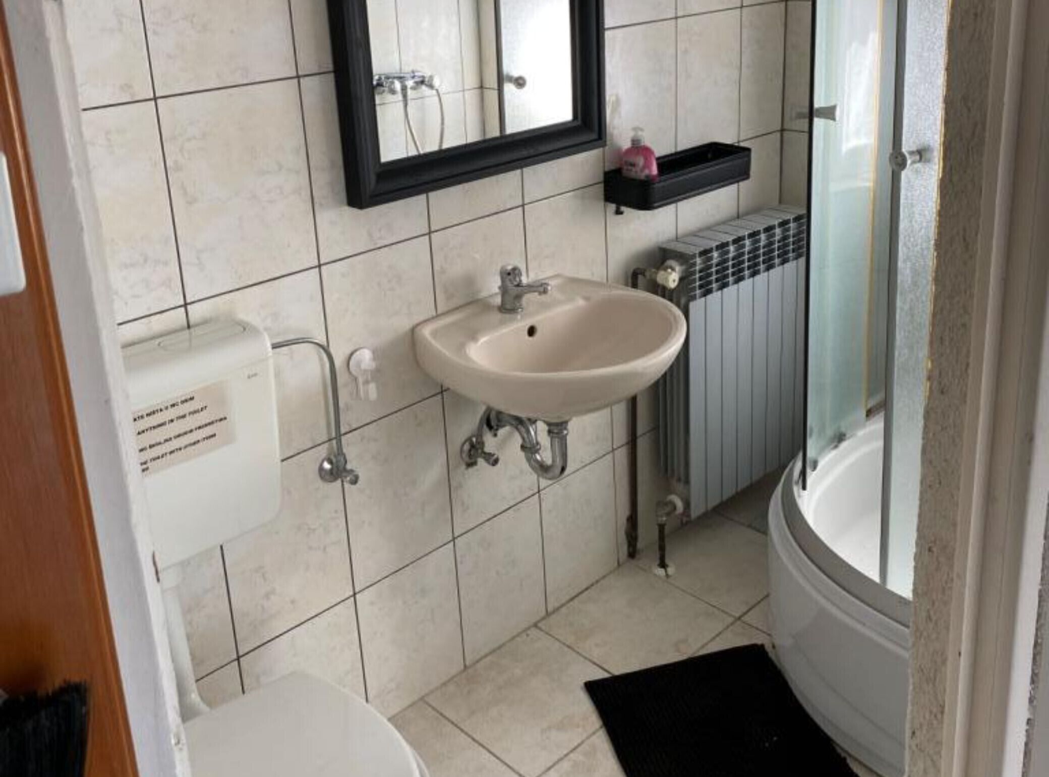 Un baño con inodoro, lavabo y zona de ducha.