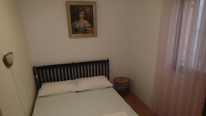 A bedroom with a bed, a bedside table, a lamp, and a painting on the wall. - Apartments Marija Kruševo A2+2 (Kruševo)