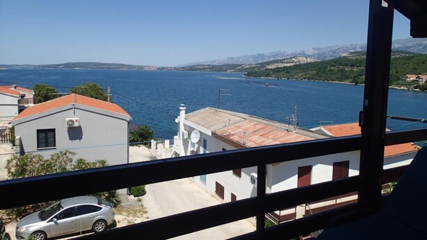 A view of a coastal area with buildings, a car, and a clear sky. - Apartments Marija Kruševo A2+2 (Kruševo)