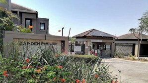 Una entrada cerrada a un complejo residencial llamado "Green Pavilion", con un letrero que indica "Solo Residentes" y una zona de entregas.