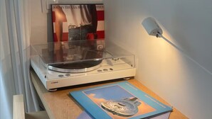 A wooden desk with a turntable, a framed poster, and a lamp. - La Petite For t Seaview Flat in Marbella (Estepona)