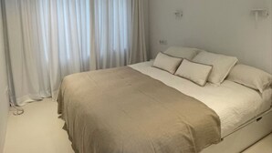 A bedroom with a bed, curtains, and a light fixture. - La Petite For t Seaview Flat in Marbella (Estepona)