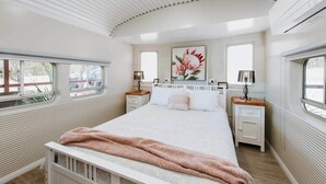 A bedroom with a bed, bedside tables, a window, and a radiator. - Red Rattler Retreat, Windeyer, Mudgee (Windeyer)