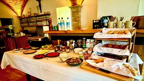 A buffet table with various food items and condiments, a coffee machine, and a bread display. - Hotel Bergen Zur Post by Rikas Hotels (Bergen)