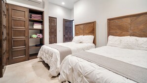 A bedroom with two beds, a wardrobe, and an air conditioning unit.