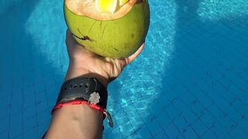 Una piscina al aire libre, sillones reclinables de piscina