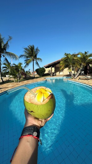 Una piscina al aire libre, sillones reclinables de piscina