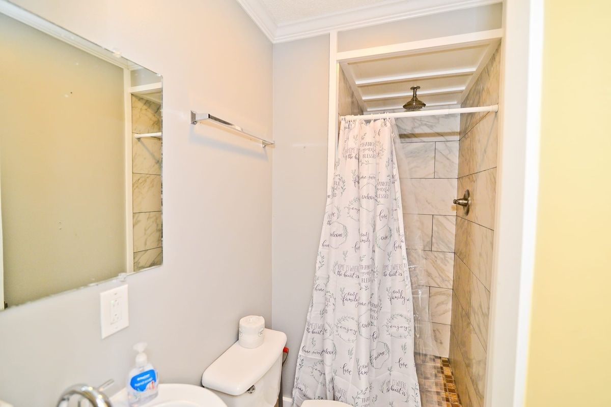 A bathroom with a toilet, sink, and shower area.