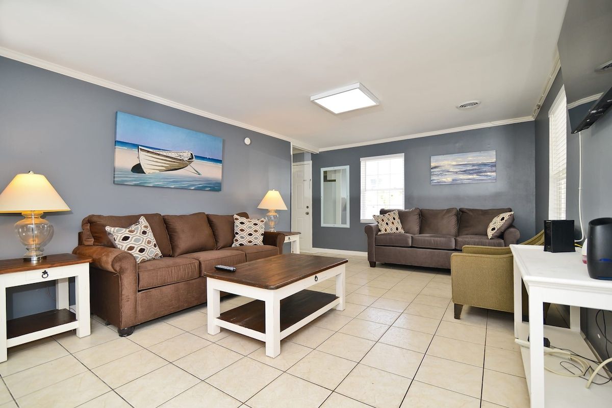 A living room with two sofas, a coffee table, and a TV stand.