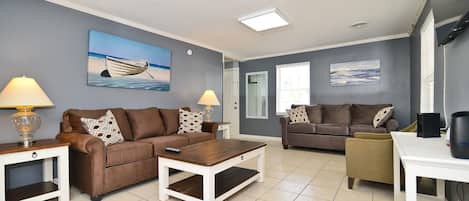 A living room with two sofas, a coffee table, and a TV stand.