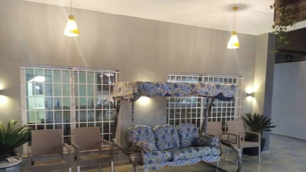 Un espace de détente moderne avec un fauteuil suspendu original, un coin salon avec des chaises et une grande fenêtre offrant une vue imprenable.