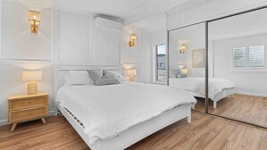 Una camera da letto moderna con un letto grande, comodini e uno specchio.