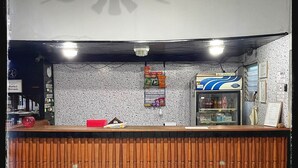 Un espace d’accueil comprenant un comptoir en bois, un distributeur automatique et un mur orné de divers panneaux.