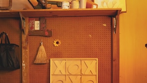 A pegboard wall with various tools and a chalkboard.