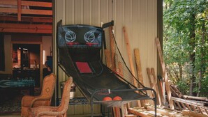 A basketball court with a net, wooden planks, and wicker chairs.