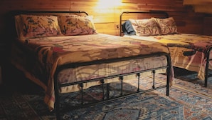 A cozy room with two beds, each with patterned bedding and a wooden headboard.