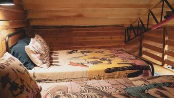 A cabin-style room with a bunk bed, wooden walls, and a sloped ceiling.