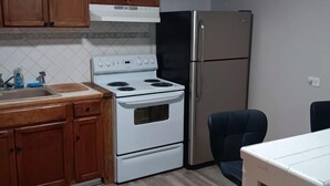 A kitchen with wooden cabinets, a white stove, a stainless steel refrigerator, and a wooden stool. - Charming, private house minutes from PADRE ISLAND  Corpus Christi. 2 full baths (Corpus Christi)