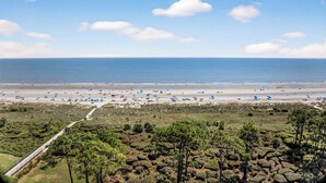 Une plage offrant une vue dégagée sur l’océan et un sentier menant à la plage.