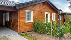 A wooden cabin with two windows and a small porch area.