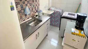 A compact kitchen with a refrigerator, sink, and a small countertop. - Apartment in Salvador in the best location. (Salvador)