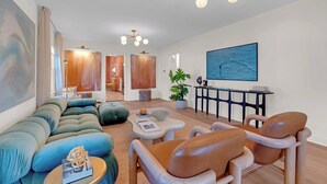 A modern living room with a sectional sofa, leather armchairs, a coffee table, and a dining area with a table and chairs. - Prof Cleaned | Linens+Towels | Fast WIFI | Coffee (Lake Como)