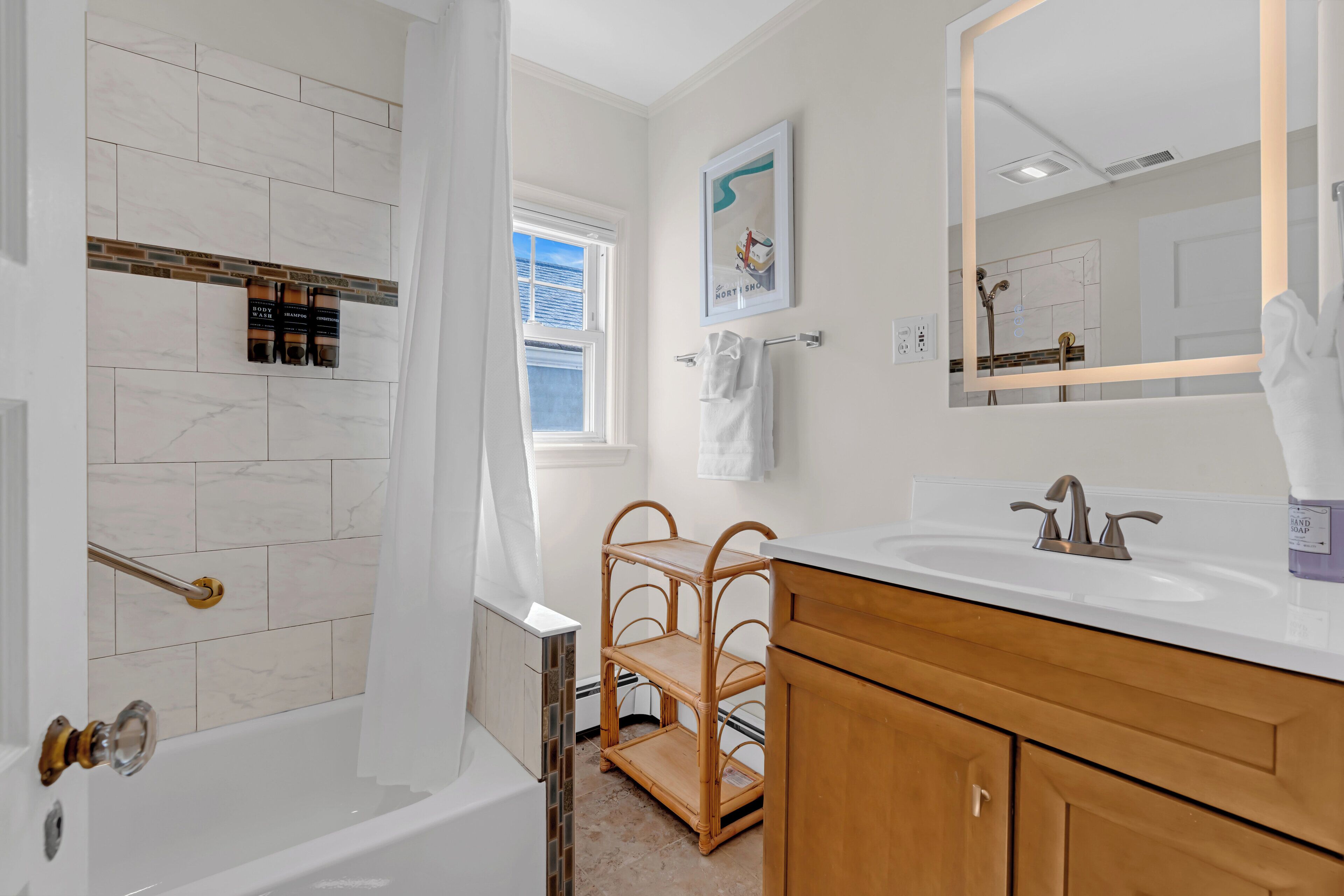 A modern bathroom with a bathtub, a vanity with a sink, and a shower.