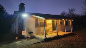 Una casa pequeña de un piso con un porche, una chimenea y un letrero que dice 'RETRO REST'.