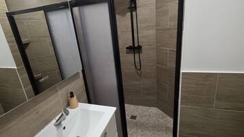 Een douche, handdoeken, zeep, shampoo