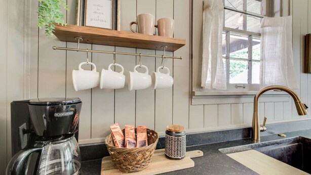 A kitchen with a coffee maker, mugs, and a basket of coffee pods. - Hot tub, 4bd Family Home - Bertrand Cottage (Manhattan)