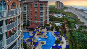 A hotel with multiple floors, a central swimming pool, and a beach view. - 2-bedroom resort in delightful Myrtle Beach with AC, fitness room (Myrtle Beach)
