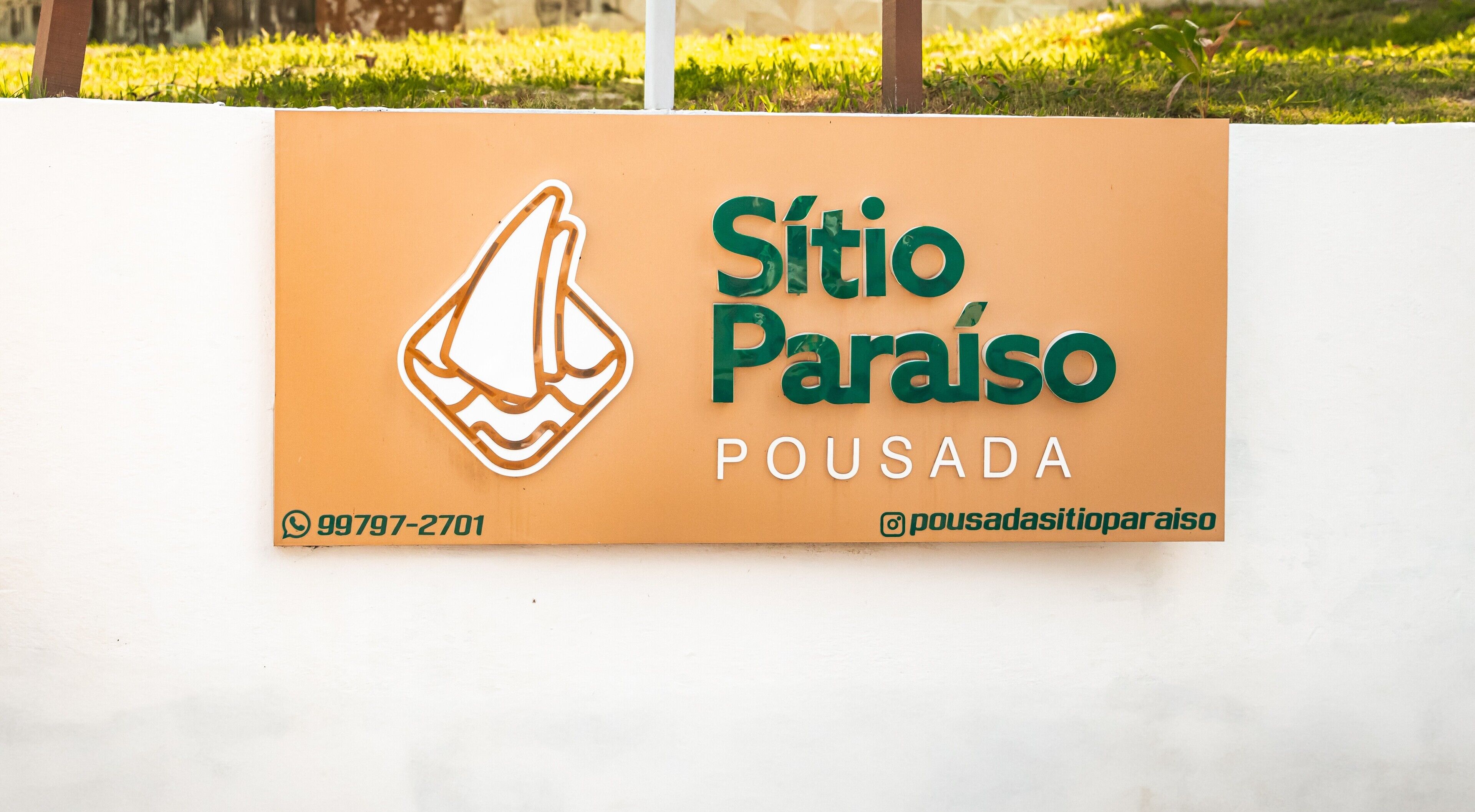 A sign with the name 'Sítio Paraíso' and the word 'POUSADA' indicating a lodging establishment.