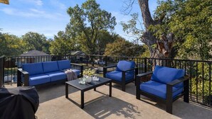 An outdoor patio with a sofa, chairs, and a table.