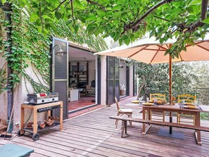 An outdoor patio with a dining table, chairs, and a grill. - Villa 50 by Interhome (Théoule sur mer)
