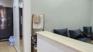 Et moderne interiør med en receptionsdisk, en sofa med puder, og en gang der fører til en dør.