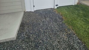 A gated outdoor area with a gravel path leading to a building entrance. - Cozy 2BR Home Parking and Full Kitchen (Stanfield)