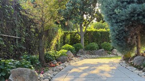 A stone pathway in a garden with various plants and trees. - Cozy 1-Bedroom Guesthouse in the Country with HVAC, in Lodi (Lodi)