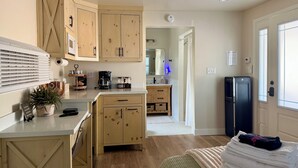 A kitchen with wooden cabinets, a coffee maker, and a refrigerator. - Cozy 1-Bedroom Guesthouse in the Country with HVAC, in Lodi (Lodi)