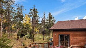 A wooden cabin with a deck, surrounded by trees and a clear sky. - Luxury Evergreen Retreat · Fireplace · Mountain Views · 45 min Denver  (Evergreen)