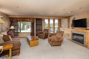 A living room with a sofa, armchairs, a coffee table, a fireplace, and a TV. - Ski-in/ski-out, Community Pool/Hot Tub, Fireplace, Big Sky Resort (Big Sky)
