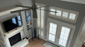 Una sala de estar moderna con chimenea, televisor y ventilador de techo.