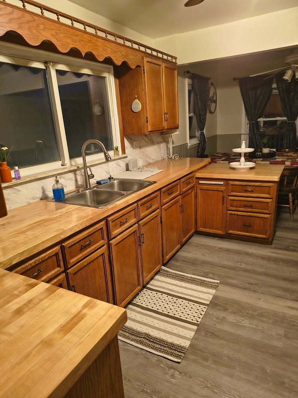 A kitchen with wooden cabinets, a sink, and a window.