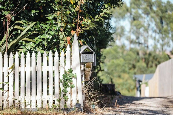 A white picket fence with a mailbox and a small house-like structure attached to it. - Cosy container house walking distance to town. (Korumburra)