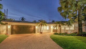 A two-story house with a garage, a paved driveway, and well-maintained lawn.
