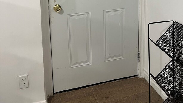 Puerta blanca con un panel de vidrio decorativo y pomo de latón.