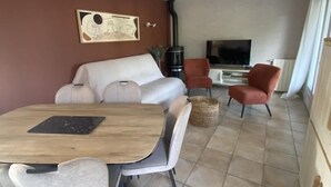 Una sala de estar moderna con un sofá, una mesa de comedor y un televisor.